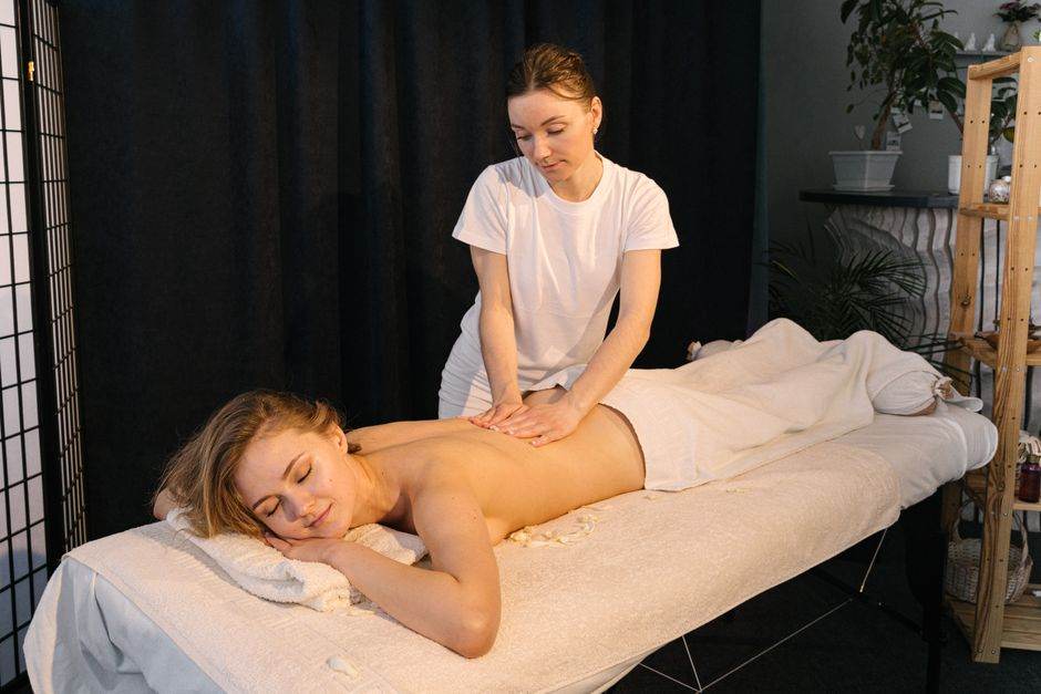 Therapist giving a massage in a bright spa room