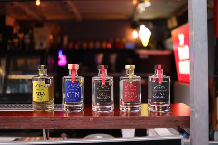 Row of small labelled gin bottles on a bar shelf