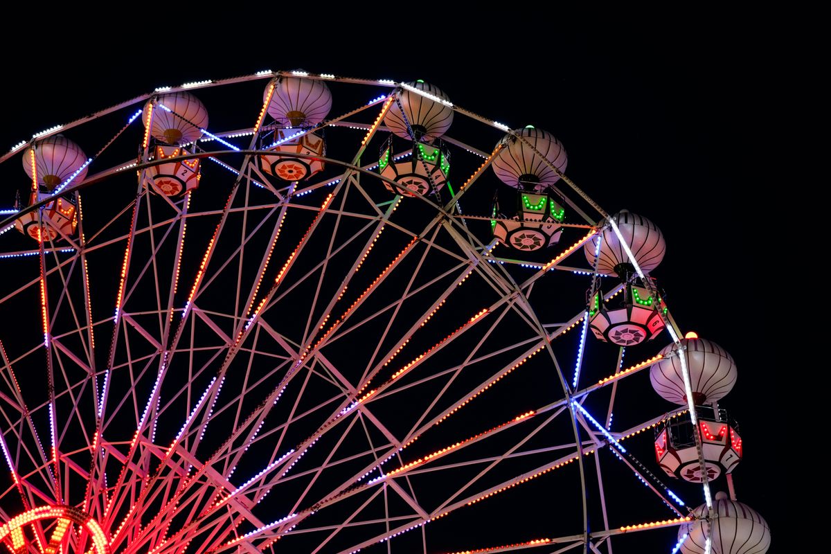 Ferris wheel glowing red and pink against a night sky