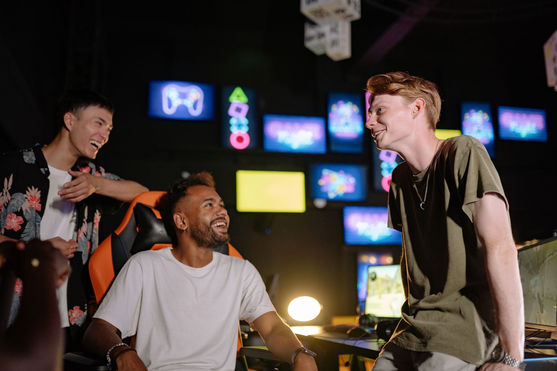 Friends laughing together in a dark arcade room with neon signs