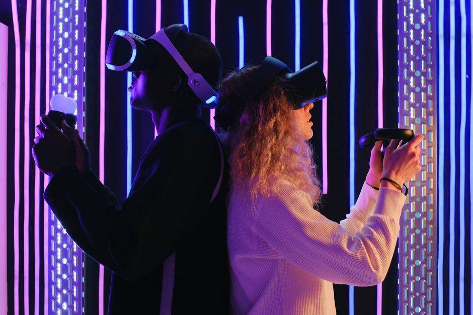 Two players in VR headsets in a neon-lit room